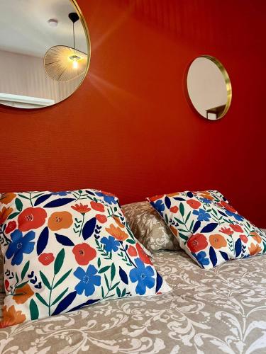une chambre avec un lit avec deux oreillers et un miroir dans l'établissement Le Quiet Spot, plein coeur de Bayeux, à Bayeux