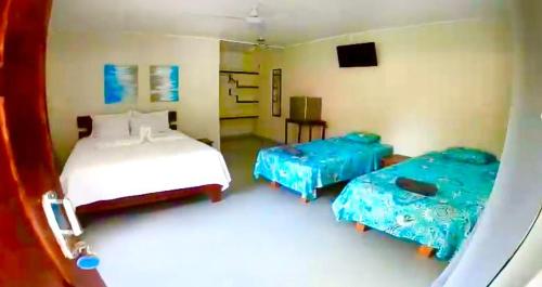 a bedroom with two beds and a tv in it at El Sueno Tropical in Carrillo