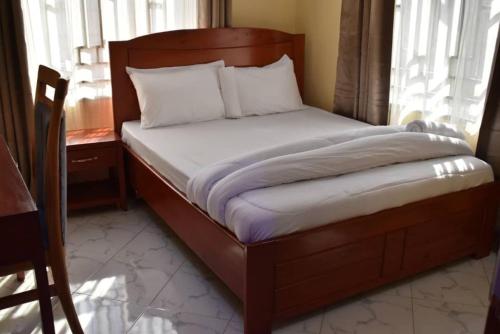 a bed with a wooden frame in a room at Volunteer House in Msaranga