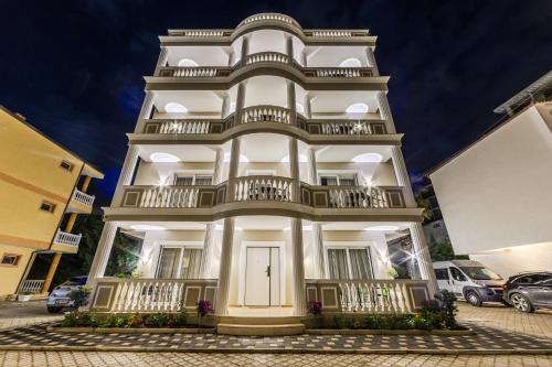 a tall white building with balconies on it at Sea La Vie Apartment in Golem
