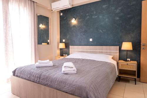 a bedroom with a large bed with towels on it at DreamCoast Apartments I in Artemida