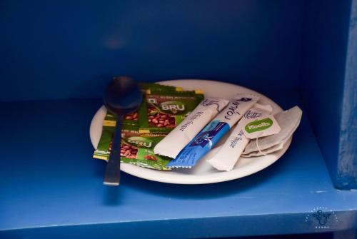 a plate with toothpaste and toothbrushes and a spoon at The Change Hotel in Kandy