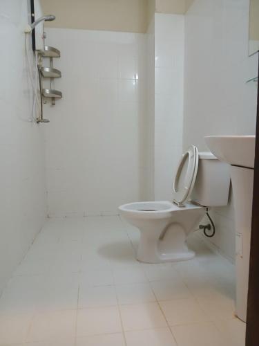 a white bathroom with a toilet and a sink at Vang Vieng Camellia Hotel in Vang Vieng