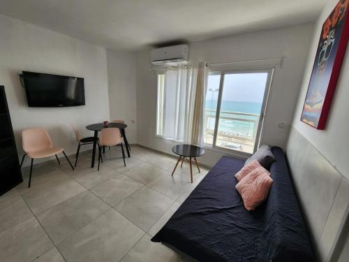 a living room with a couch and a view of the ocean at Premium 2BR Sea View Apartment Bat Yam in Bat Yam