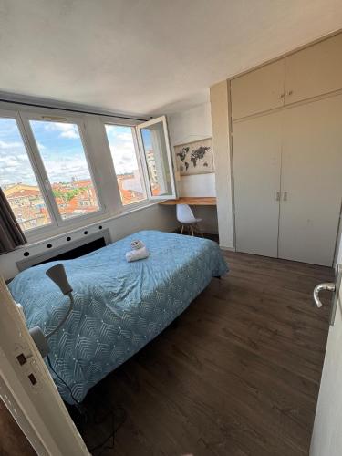 une chambre avec un lit avec un animal en peluche dessus dans l'établissement Appartement lumineux au coeur de Valence 52, à Valence