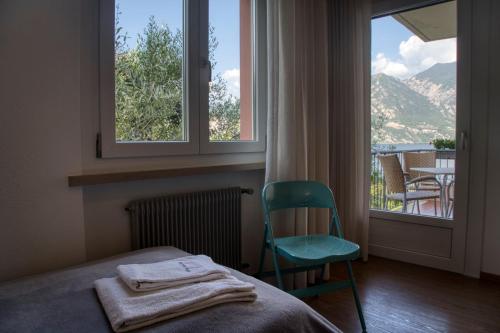a bedroom with a bed and a chair and a window at Villa Andreis in Malcesine