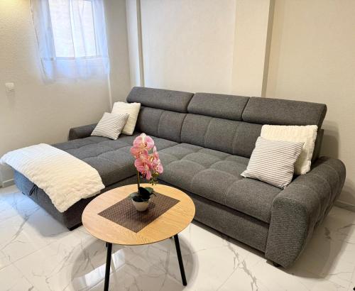 a living room with a couch and a table at Modern Brand-New Apartment in Makarska