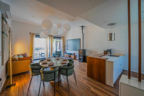 une cuisine et un salon avec une table et des chaises dans l'établissement Maison La Fontaine, à Gières