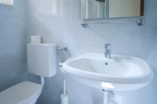 a white bathroom with a toilet and a sink at Villa Andreis in Malcesine