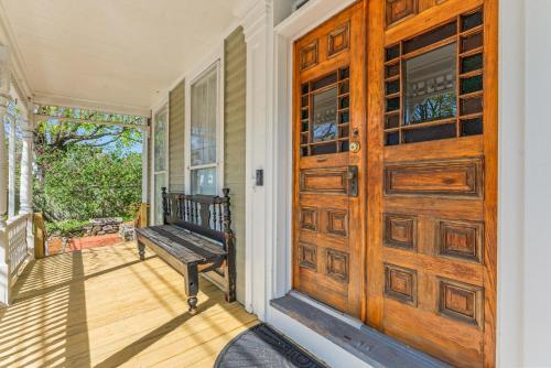 a porch with a wooden door and a bench at Charming 4BR Victorian Mystic Downtown in Groton