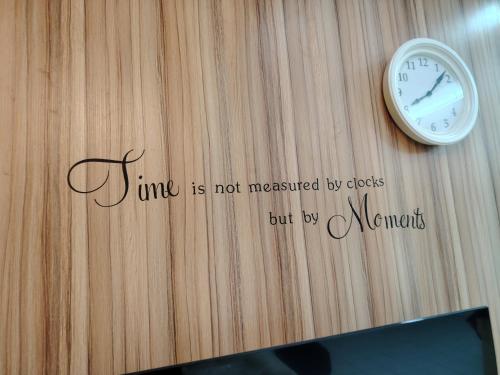 a clock on a wall with the words time is not measured by deeds but be at DIAZ Homestay in Sungai Buluh