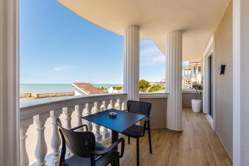 a balcony with a table and chairs and a view of the ocean at Sea La Vie Suites in Golem