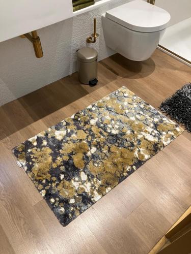 a bathroom with a rug on the floor next to a toilet at Lectoure - the retreat B&B in Lectoure