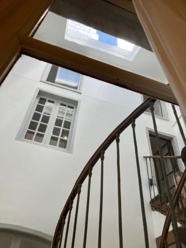 a staircase leading to a white building with windows at Lectoure - the retreat B&B in Lectoure