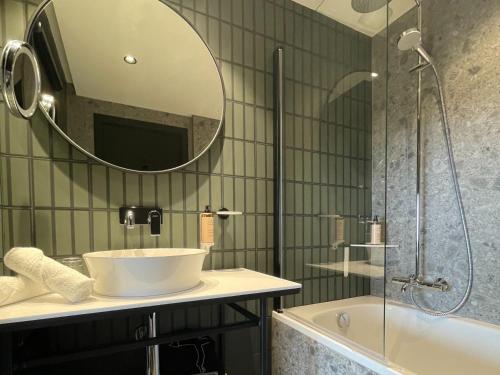 a bathroom with a sink and a tub and a mirror at Mercure Dijon Centre Clemenceau in Dijon