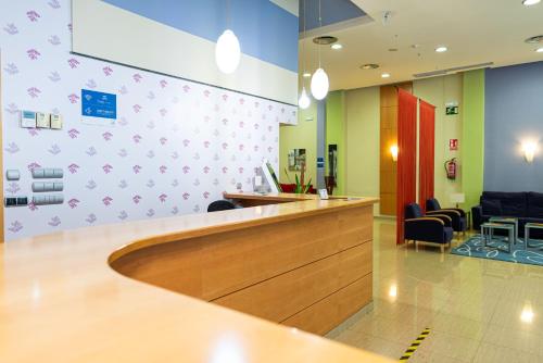 a waiting area of a hospital with a counter and chairs at Hotel Alda Xinzo in Xinzo de Limia