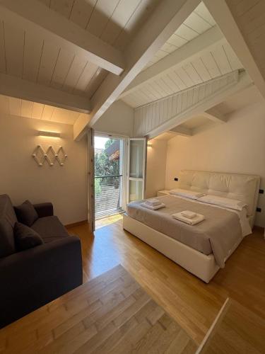 a large bedroom with a large bed and a couch at Brescia Living in Brescia