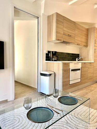 une cuisine avec deux assiettes sur une table en verre dans l'établissement Charmant T2 à deux pas du cours Mirabeau, à Aix-en-Provence