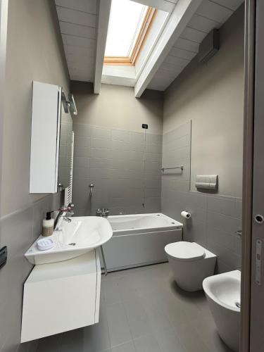 a bathroom with a sink and a tub and a toilet at Brescia Living in Brescia