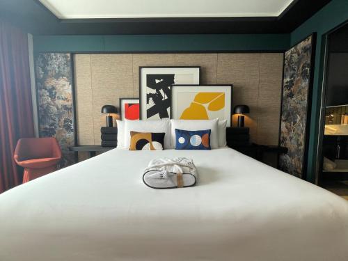 a bedroom with a large white bed with a pair of shoes on it at Mercure Dijon Centre Clemenceau in Dijon