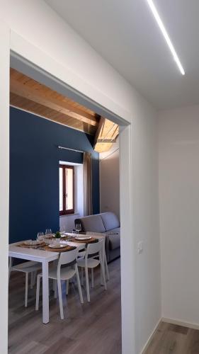 a white dining room with a table and a couch at SUITE Rosso Conero - Le Grotte Rooms And Apartments in Camerano