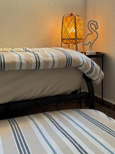 a pair of beds in a room with a lamp at El Tiburon in Playa de Gandia