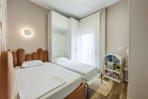 a small bedroom with two beds and a window at Chloe's Central Apartment in Durrës