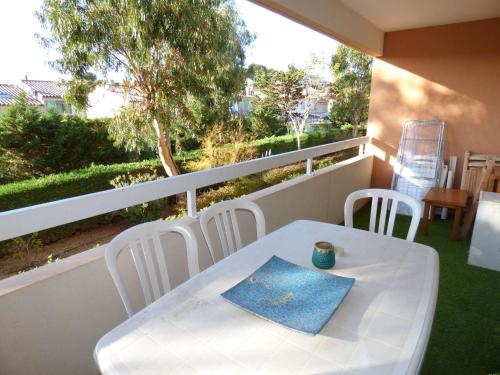 une table blanche et des chaises sur un balcon dans l'établissement Piscine, plages à proximité, internet et parking privé, à La Seyne-sur-Mer