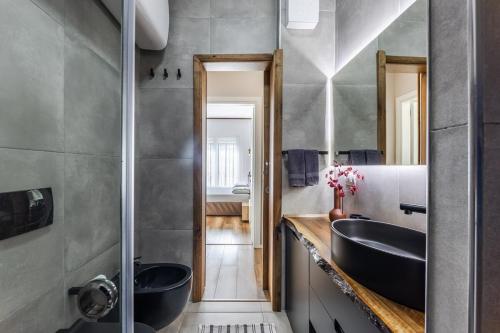 a bathroom with two black sinks and a mirror at Chloe's Central Apartment in Durrës