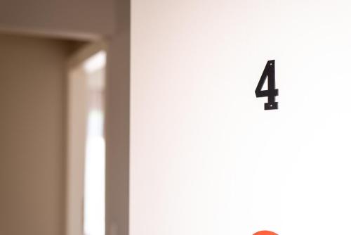 a clock with the number four on the wall at DreamCoast Apartments I in Artemida