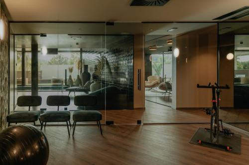 a room with glass walls and chairs and a gym at Hotel Leiriartem by Grupo Quinta dos Lagos in Leiria