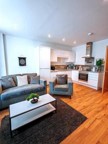 a living room with two couches and a table at The Cosy Quarters - Popworks in Manchester