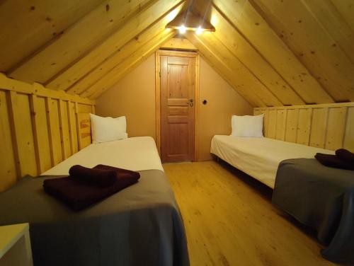 a bedroom with two beds in a wooden cabin at Lainela puhkeküla in Käsmu