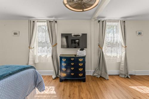 a bedroom with a blue dresser and two windows at Charming 4BR Victorian Mystic Downtown in Groton