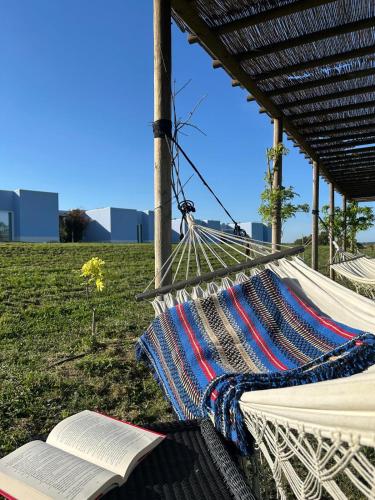 a hammock with an open book on the grass at Sleep & Nature Hotel in Lavre
