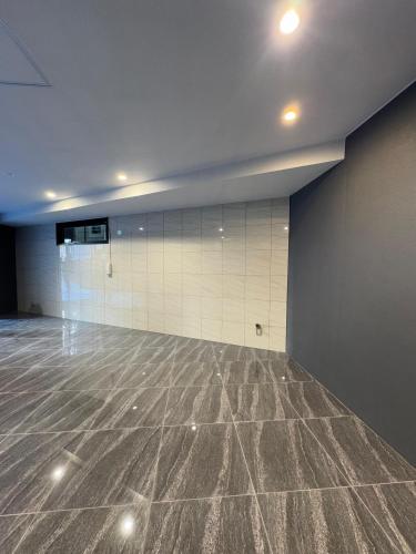 an empty room with a marble floor and white tiles at The Peak Tsutenkaku Elite in Osaka