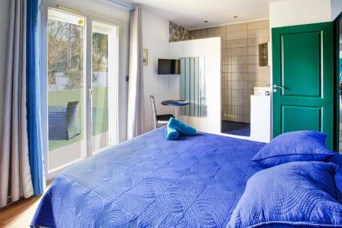 - une chambre avec un lit bleu et une grande fenêtre dans l'établissement Villa Grenache by Villa Plus, à Usclas-lʼHérault