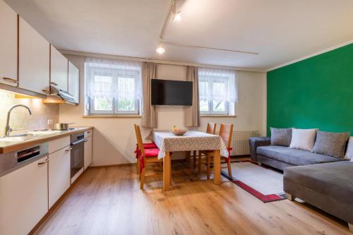 a kitchen and living room with a table and a couch at DORF 77 Apartment in Elbigenalp