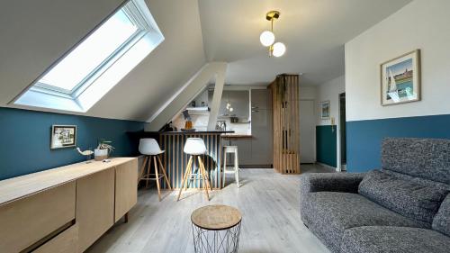 un salon avec un canapé et une fenêtre dans l'établissement Le Salicorne, au Crotoy