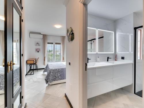 Un dormitorio con armarios blancos y una cama y un baño. en Villa Nina Marbella, en Marbella