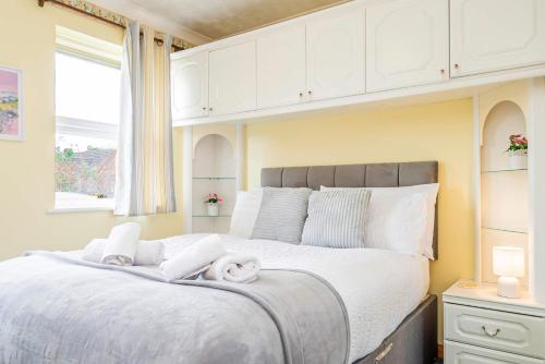 a bedroom with a large bed with towels on it at Spacious 4 Bedroom Home in Central Milton Keynes in Milton Keynes