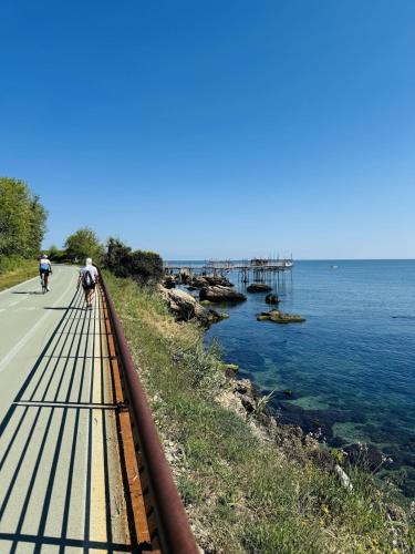 a couple of people riding bikes on a road next to the water at Casa DeDa-Mare & Design on the Trabocchi Coast in Fossacesia