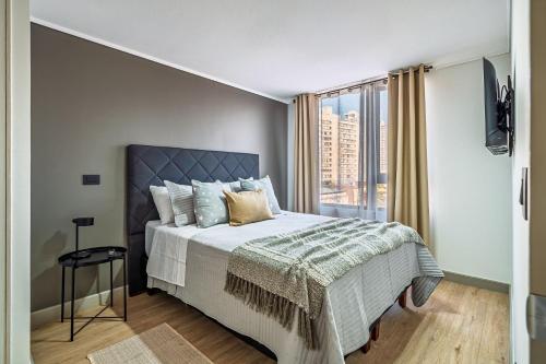 ein Schlafzimmer mit einem Bett und einem großen Fenster in der Unterkunft Centro Cívico - GYM - Piscina - WiFi - Terraza - Security 24-7 in Santiago