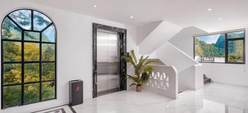 a room with white walls and windows and a staircase at Yangshuo KIRA Hotel - Moroccan Style in Yangshuo