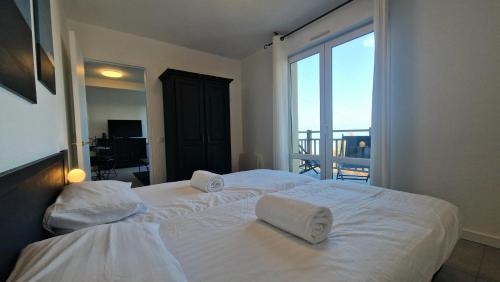 - une chambre avec un grand lit blanc et un balcon dans l'établissement Appartement avec piscine Bleu du Lac, à Évian-les-Bains