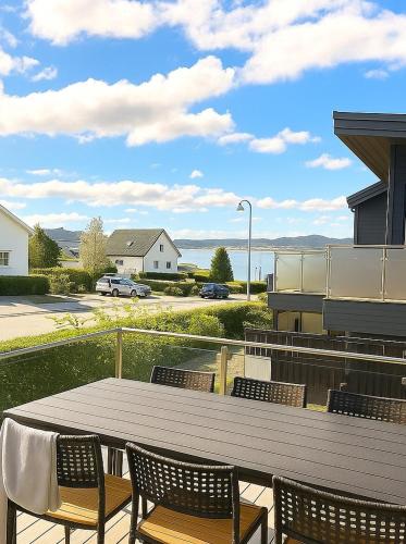 a table and chairs on a patio with a view of the water at Panoramic View & Comfort in Ålesund