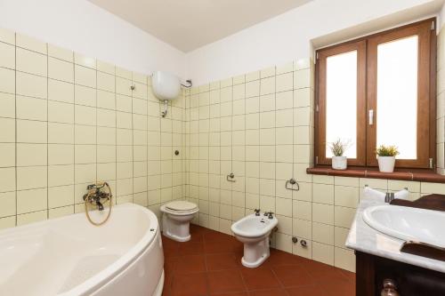 a bathroom with a tub and a toilet and a sink at Casa Isolotto D'Ogliastra - vista mare in Lotzorai