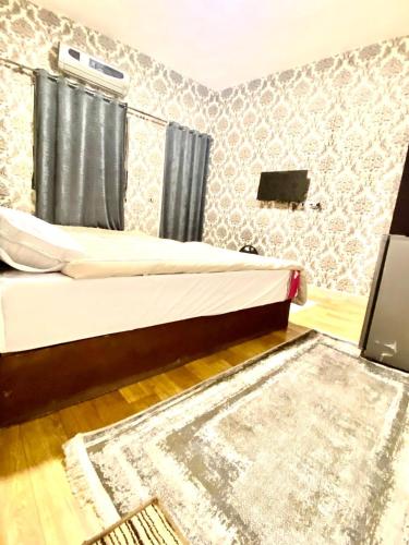 a bedroom with a bed and a television and a rug at sphinx one centre hotel in Banī Ghālib