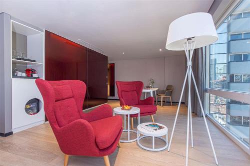 a living room with two red chairs and a table at NH Collection Mexico City Reforma in Mexico City