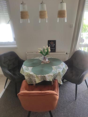 a table with a vase of flowers on top of two chairs at Euro szallas in Pusztavacs